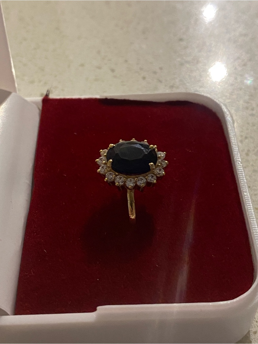 Gold Ring with sapphire centre and cubic zirconia stones surrounding the ring